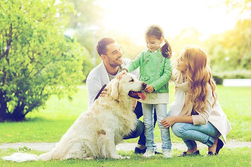 family, pet, domestic animal and people concept-happy family with labrador retriever dog on walk in summer park