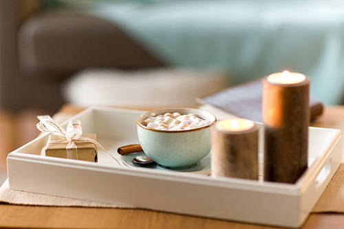 holidays and still life concept - hot chocolate with marshmallow, christmas gift and candles on table