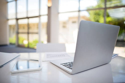 Laptop and digital tablet on table at conference center