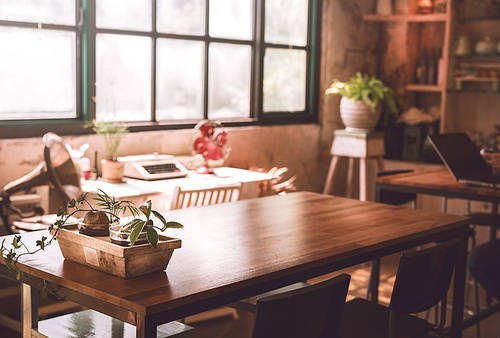 Tables and desks in a study room brightly lit by sunlight