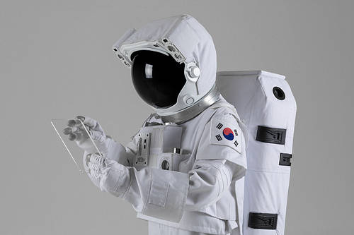 Space Life-Side view of an astronaut browsing a virtual reality tablet