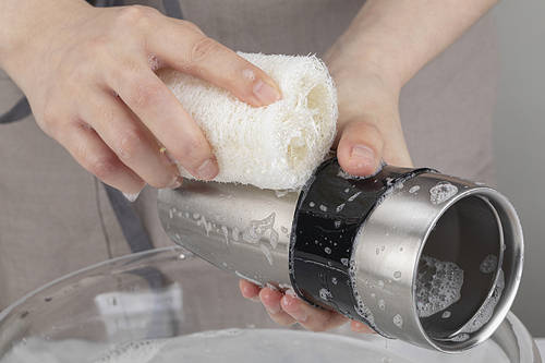 Zero Waste - Wiping the stainless steel tumbler with a natural loofah that lathers with detergent