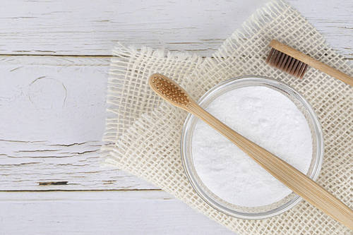 Zero waste - bamboo toothbrush and baking soda on white wooden background, linen cloth