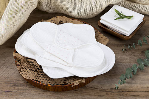 Zero waste-wooden background, natural cotton sanitary pads on a wooden plate