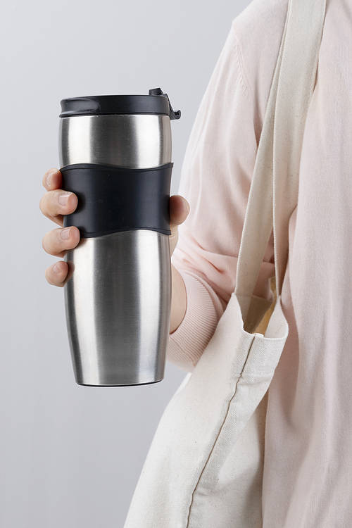 Zero Waste - A person wearing an eco bag and holding a tumbler