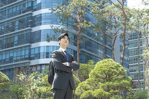 A day of a young new employee-A young new employee looking away with arms folded