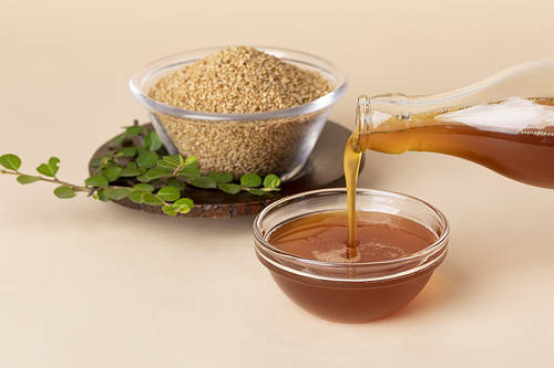 Sesame seeds - Sesame seeds in a glass bowl and pouring sesame oil
