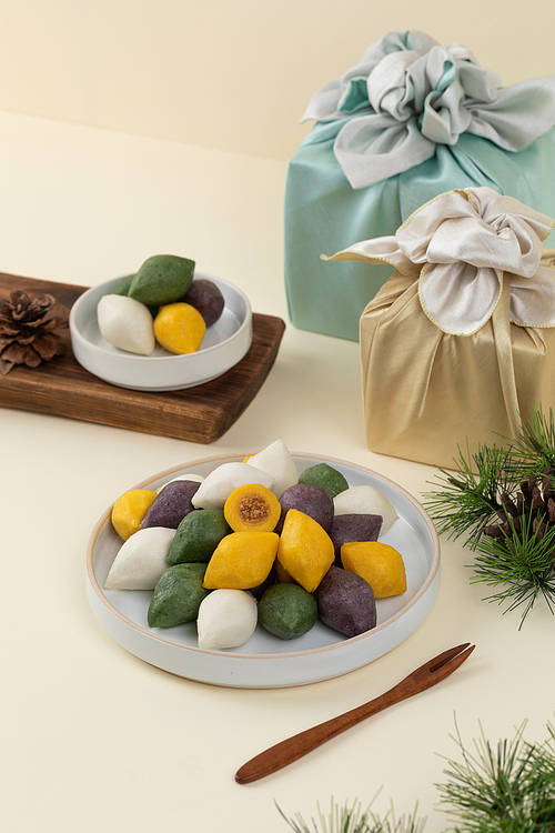 Holiday gift set_a bowl with songpyeon and a box wrapped in pine needles and pine cone furoshiki