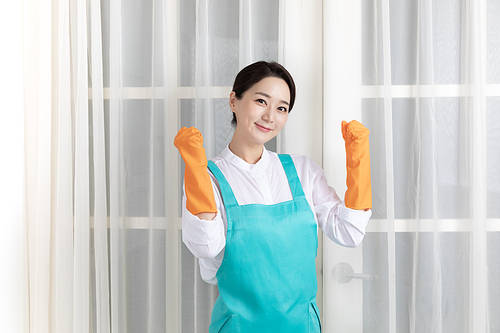 A scene image of a woman wearing an apron wearing rubber gloves and taking a fighting pose