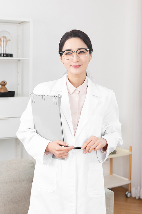 Image of a woman wearing a white gown and holding a chart