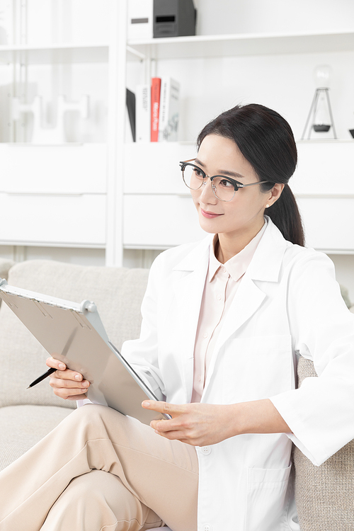 Image photo of a psychiatrist and female doctor sitting on a sofa and holding a chart