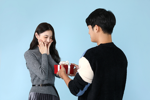 Photo of a man giving a gift and a woman rejoicing