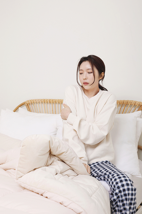 Winter indoor daily life_ A photo of a woman shivering in the cold