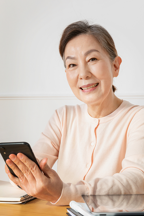 Senior Woman_Photo of a middle-aged woman looking at a cell phone