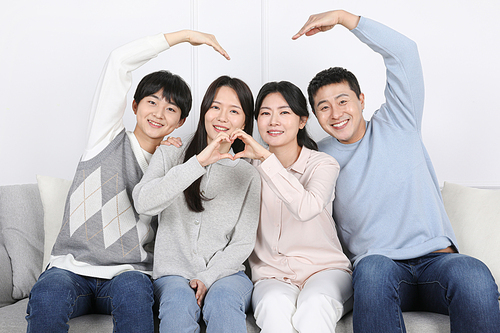 My Family_ A photo image of a family sitting side by side and posing for a hand heart