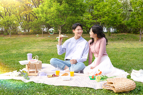 Couple picnic_photo image of lovers playing with soap bubbles