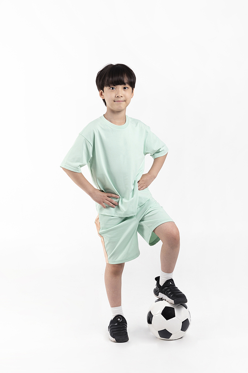 Photo image of a child_stepping on a soccer ball