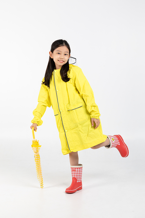 Photo image of children wearing raincoats and holding umbrellas