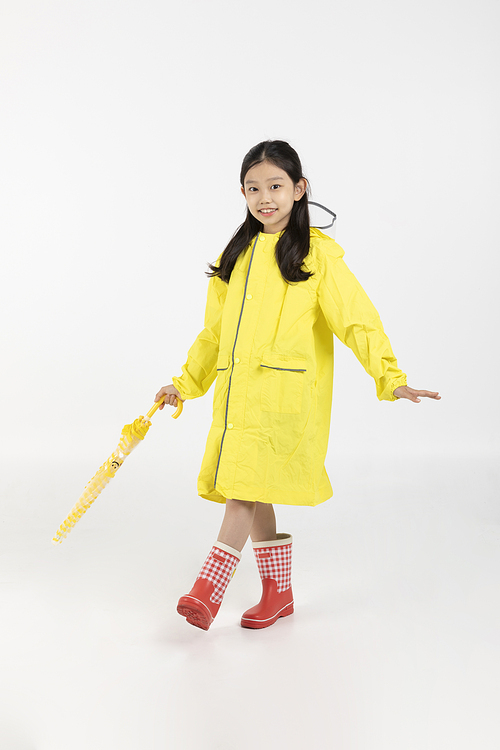 Photo image of children wearing raincoats and holding umbrellas