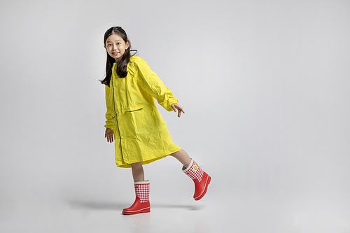 Photo image of children walking forward wearing raincoats