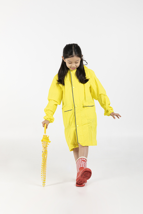 Child_Picture image of a child wearing a raincoat and holding an umbrella