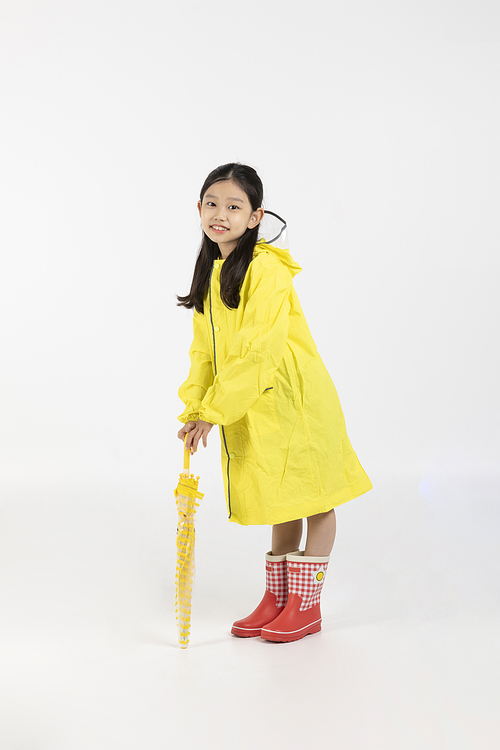 Child_Picture image of a child wearing a raincoat and holding an umbrella