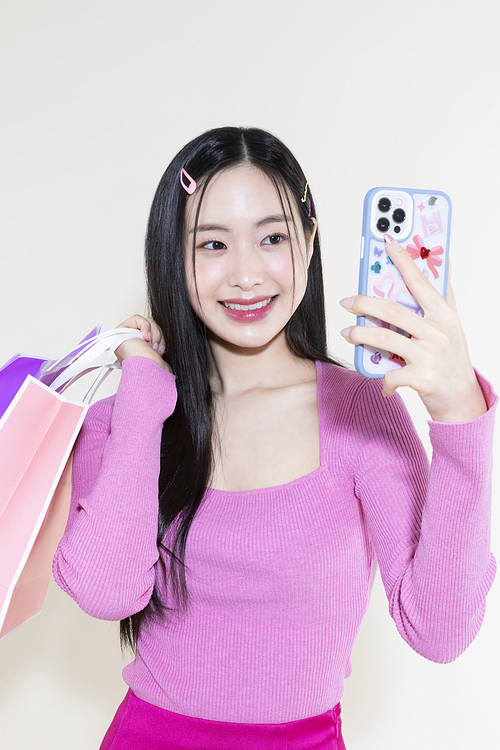 Y2K Lifestyle_Concept photo of a woman holding a smartphone and shopping bags