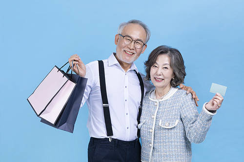 Hip old age_Photo image of seniors holding shopping bags and credit cards