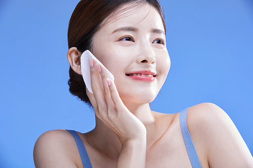 Photo image of a woman using a cleansing pad