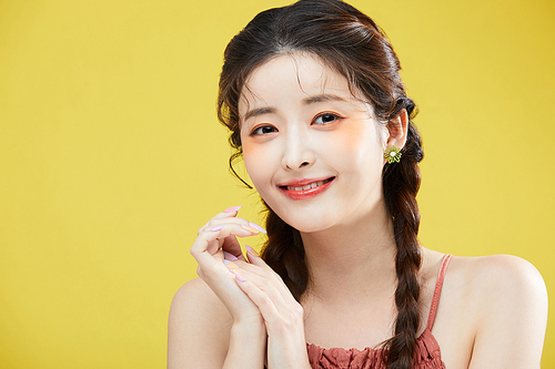 Photo image of a woman braiding her hair and smiling