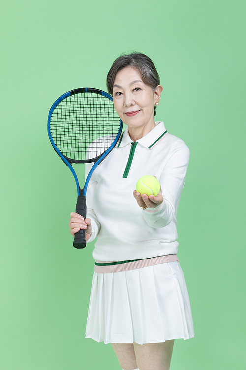 Everyone's hobby_Photo image of a senior woman holding a tennis racket and a tennis ball