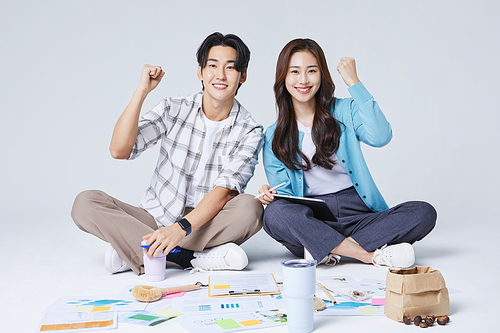 Collaborative Business_Photo image of a man and woman sitting cross-legged and cheering