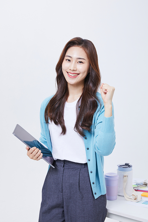 Office cooperation business_photo image of a woman standing next to a desk with various documents and materials holding files