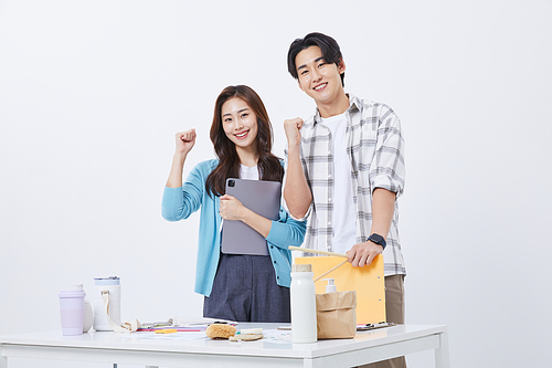 Office cooperation business_photo image of a man and woman cheering with tablets and files