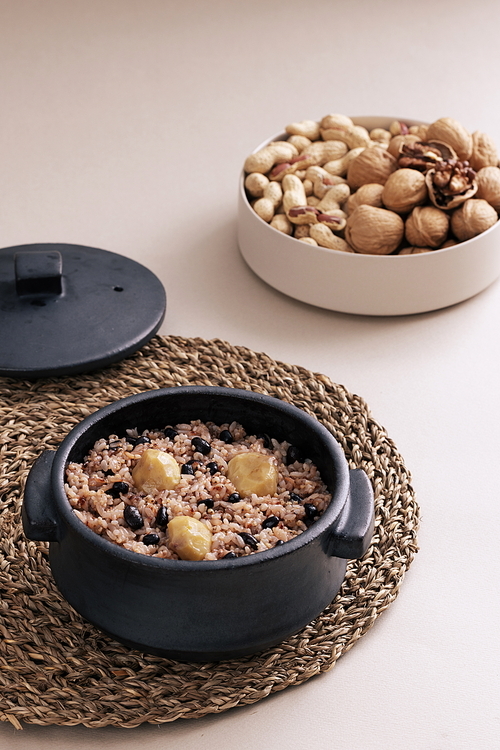 The pot is filled with five-grain rice, and the plate is filled with peanuts and walnuts.