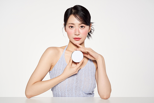 Asian woman holding a cushion compact with both hands