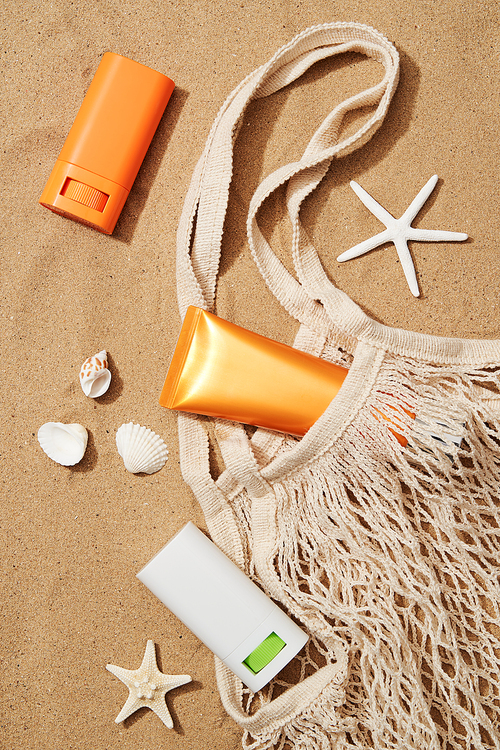 Net bag and sunscreen on the sand