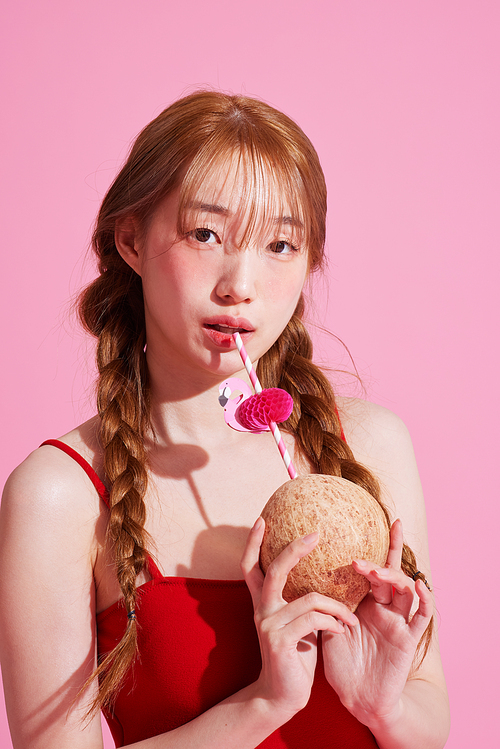 Korean woman in her 20s holding a coconut drink