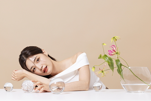 A woman in her 20s in front of a table decorated with flowers