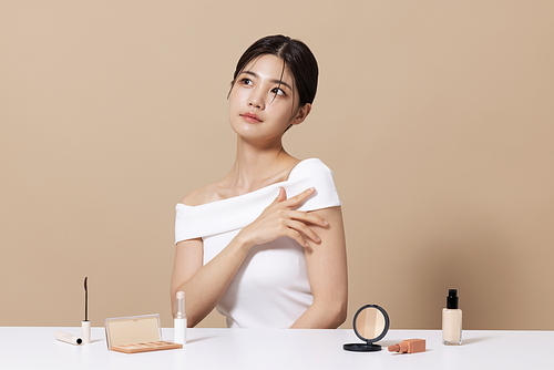 A woman in her 20s posing in front of cosmetics