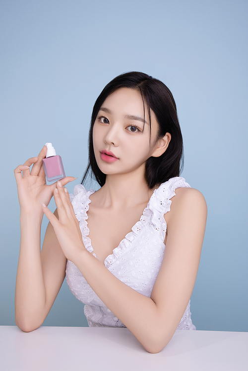 A woman in her 20s posing with a cool-toned lip product