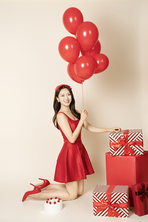 A woman in her 20s posing with a balloon