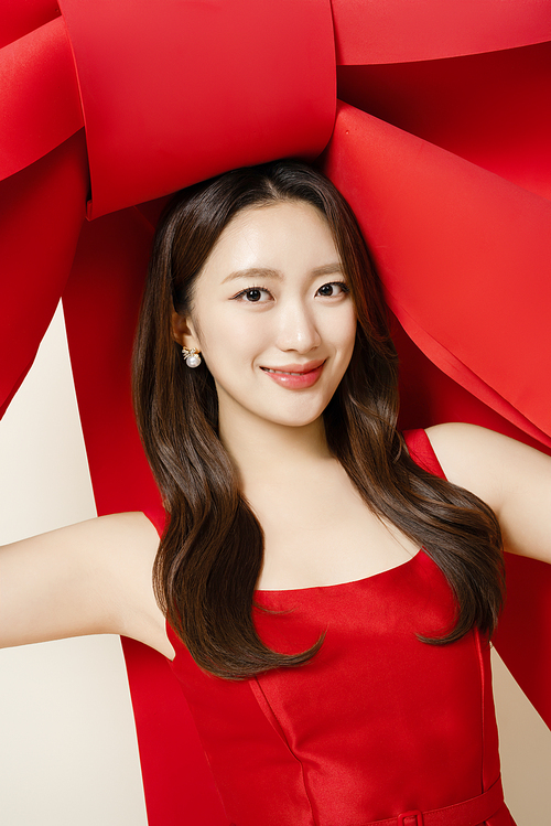 A woman in her 20s posing with a large ribbon