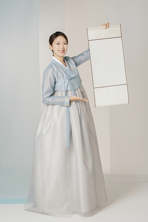 A beautiful woman wearing an elegant Hanbok and holding a traditional scroll scroll.